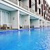 R Hotel Rancamaya, Bogor: long outdoor pool beside modern hotel rooms and balconies