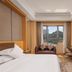 Lakeside Resort Jingdezhen guest room with king bed, desk, and window view of hills