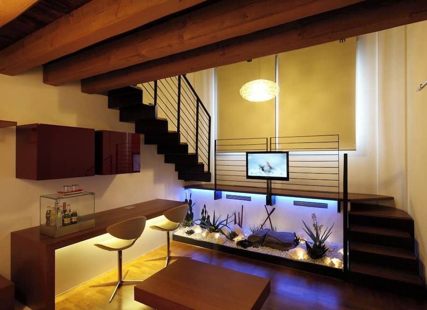Relais Ca' Sabbioni in Mira: modern loft interior with staircase and illuminated aquarium feature