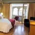 La Freixera in Solsona: stone-walled bedroom with king bed, balcony doors, and arched courtyard view