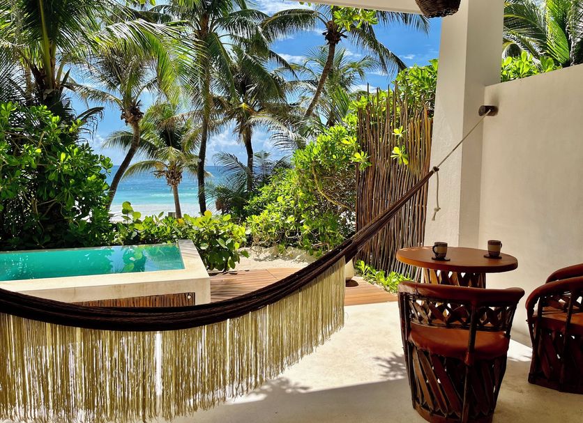 The Beach Tulum Hotel in Tulum: hammock on a terrace with partial ocean view and palm trees