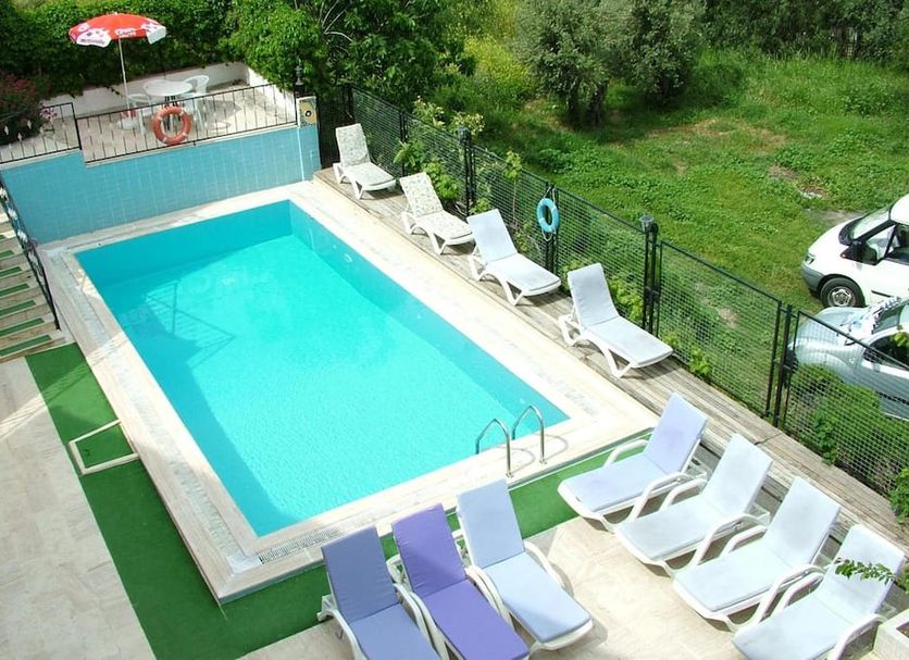 Gultepe Apartments in Kusadasi outdoor pool with sun loungers and grassy views