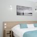Hotel La Voile, Bormes-les-Mimosas guest room with king bed, sea-themed art and balcony curtain