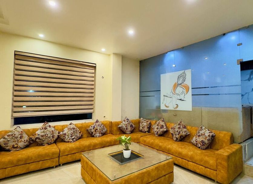 Hotel Jagdish Residency in Katra: L-shaped mustard sofa seating with coffee table in a modern lounge