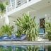 Gili Amor Boutique Resort in Pemenang, tropical poolside lounge with blue cushions and lush plants