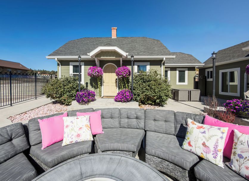 Eo Bungalows, Custer: outdoor patio seating with gray sectional and pink pillows facing bungalow cottages