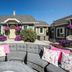 Eo Bungalows, Custer: outdoor patio seating with gray sectional and pink pillows facing bungalow cottages