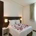 Intercity João Pessoa guest room with double bed, rose petals, bedside lamps and window curtains
