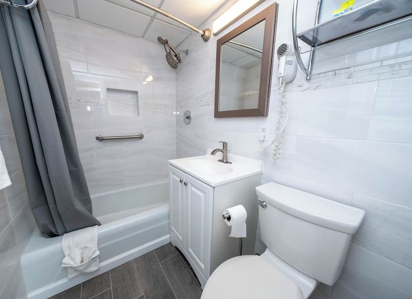 Nassau Inn Beachfront bathroom in Wildwood Crest with shower-tub combo, vanity, and toilet