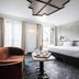 Hotel Les Bains Paris room in Paris with bed, chair, table and balcony doors