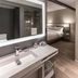 AC Hotel Fort Worth Downtown room with vanity, open closet, bed nook, and mini fridge in Fort Worth