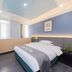 Chongqing Yueyou Hotel North New District Qibo Hotel guest room with bed, windows, desk and blue accent wall