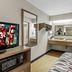 Red Roof Inn Dayton North Airport Dayton room with TV, microwave, sink vanity and patterned bed