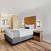 Travelodge by Wyndham San Clemente Beach guest room with king bed, TV, and vanity in San Clemente