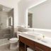 Element Ontario Rancho Cucamonga bathroom with glass walk-in shower, toilet, and large illuminated mirror