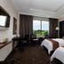 Hermes Palace Hotel Banda Aceh guest room with two beds and a window view of greenery