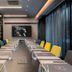 NYX Tel Aviv meeting room with long conference table, yellow and blue chairs, and wall art