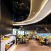 Hampton By Hilton Beijing Wangjing restaurant with curved ceiling, yellow chairs, and buffet counter