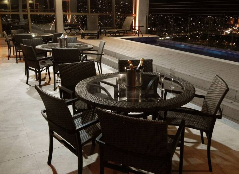 Hotel Beaga Convention Expominas By Mhb rooftop terrace with tables and city lights in Belo Horizonte