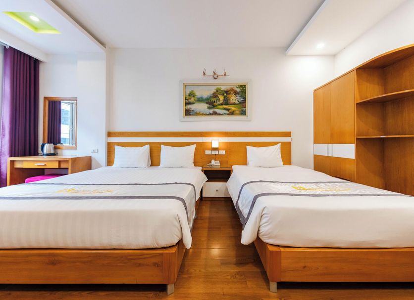 Home Hotel Hanoi twin room with two beds, wood floors, desk, mirror, and built-in wooden shelving