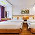Home Hotel Hanoi twin room with two beds, wood floors, desk, mirror, and built-in wooden shelving
