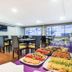 Breakfast buffet at Travelers Obelisco Apartamentos in Bogotá with fruit, pastries and dining tables