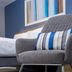 Travelodge London Twickenham guest room with gray armchair, striped cushion, and bed