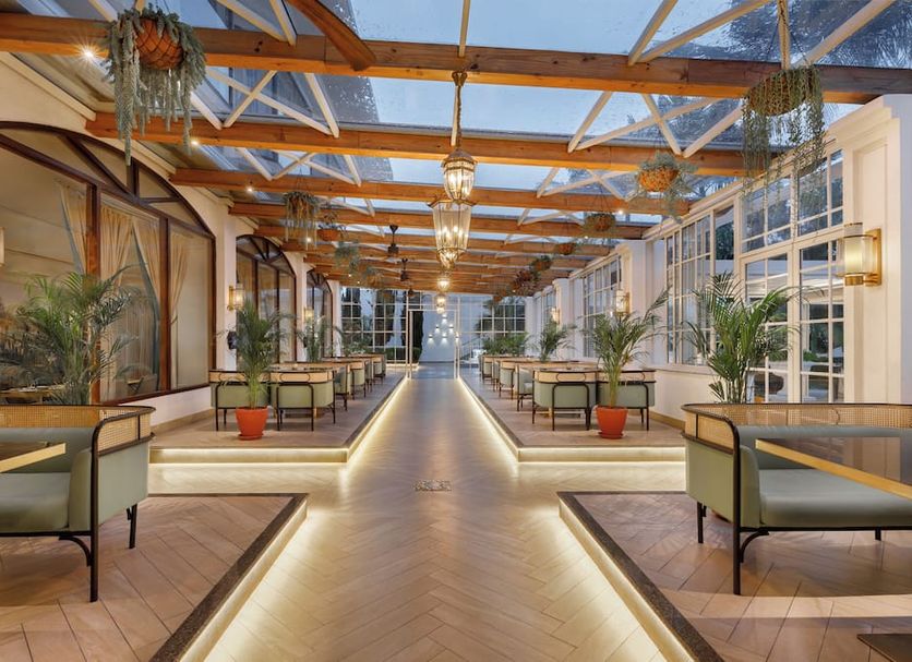 Hotel Himalaya Kathmandu in Kathmandu: bright indoor corridor with wooden beams, seating, and potted plants