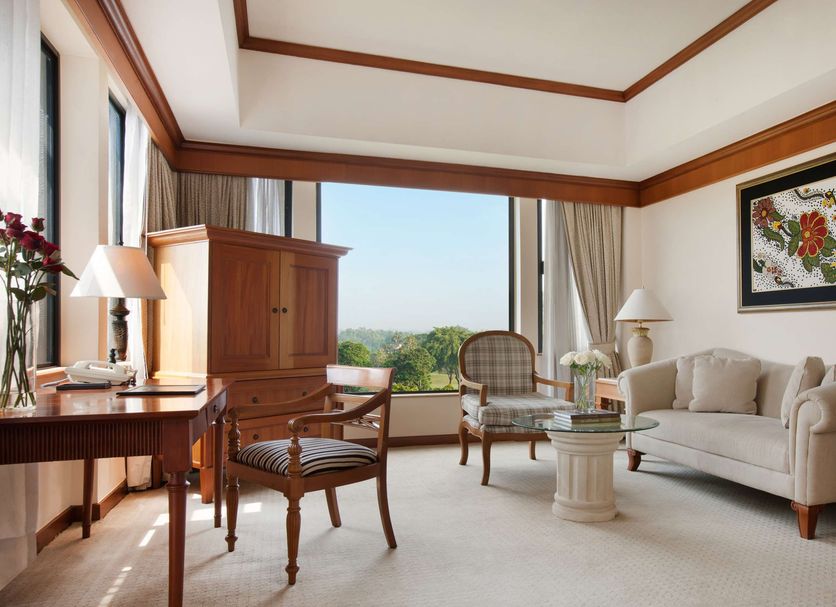 Hyatt Regency Yogyakarta suite with large window, seating area, and garden view in Yogyakarta