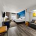 Comfort Inn & Suites Donna guest room with king bed, sofa, desk, and colorful wall art