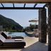 Atlantica Grand Mediterraneo Resort in Kompitsi: infinity pool, loungers, and sea view through stone pergola
