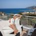 Kythea Resort in Agia Pelagia, woman relaxing on a balcony with sea and coastal village views