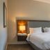 Hampton Inn & Suites Boerne guest room with king bed, desk, and window view of trees