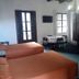 Hotel Spring in Guatemala City room with three beds, small table and chairs, chandelier, and arched mirror