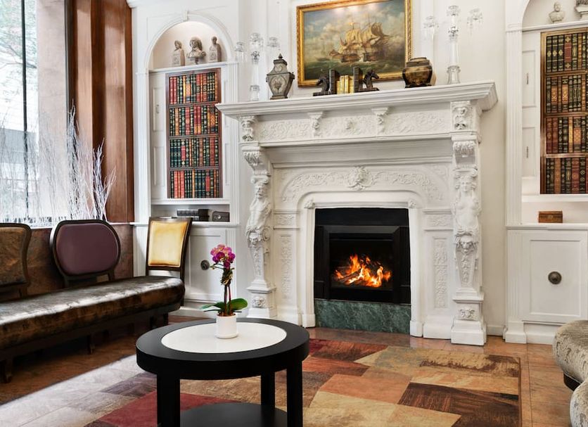 Night Hotel Broadway in New York, elegant lounge with ornate fireplace and bookshelves