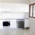 Vanuatu Beachfront Apartments Port Vila kitchen with white cabinets, oven, dishwasher and tiled floor