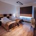 Boutique Hotel's Bytom guest room with two single beds, window blind, desk, and wall-mounted TV