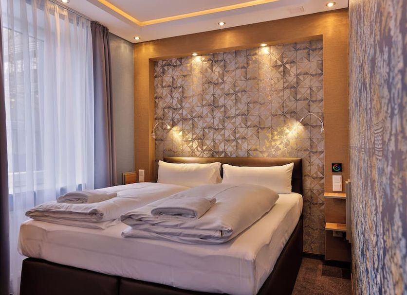Stay-Inn Bielefeld Zentrum room with double bed, folded towels, and soft ambient lighting