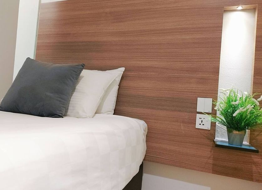 The Leverage Business Hotel - Bandar Baru Mergong room with bed, wood-paneled headboard, and bedside shelf in Alor Setar