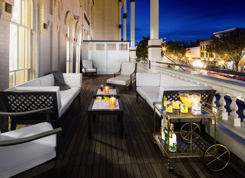 Evening balcony lounge at The Adelphi Hotel in Saratoga Springs with sofas and city views