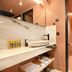 Pavo Art Hotel in Heraklion bathroom with vessel sink, marble vanity, and glass-enclosed toilet area