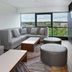 Sheraton Eatontown Hotel lounge with gray sectional seating and large windows overlooking trees