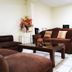 Hotel Armonía Hostal lounge in San Salvador with brown sofas, glass coffee table and tiled floor