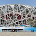 Long Ge Hotel in Beijing with a modern stadium-like building behind blue event barriers