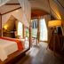Templation Hotel Siem Reap suite with canopy bed, sitting area and garden view