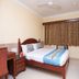 OYO 7786 Hotel Monsoon Palace room in Guwahati with bed, desk, wall-mounted TV and window curtains