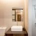 Ritsurin Boutique Hotel Phuket City bathroom with sink vanity, mirror, toilet and wall-mounted shower