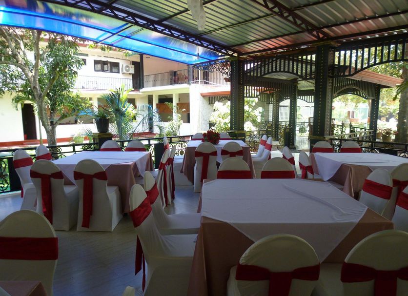 Grand Crown Hotel in Anuradhapura outdoor dining area with tables and red-and-white chair covers