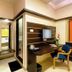 Hotel Golden Treat in Indore: compact room with desk, chair, TV, kettle, and doorway to bed area