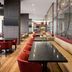 Residence Inn by Marriott Montreal Airport lounge with red chairs, tables and banquette seating in Montreal